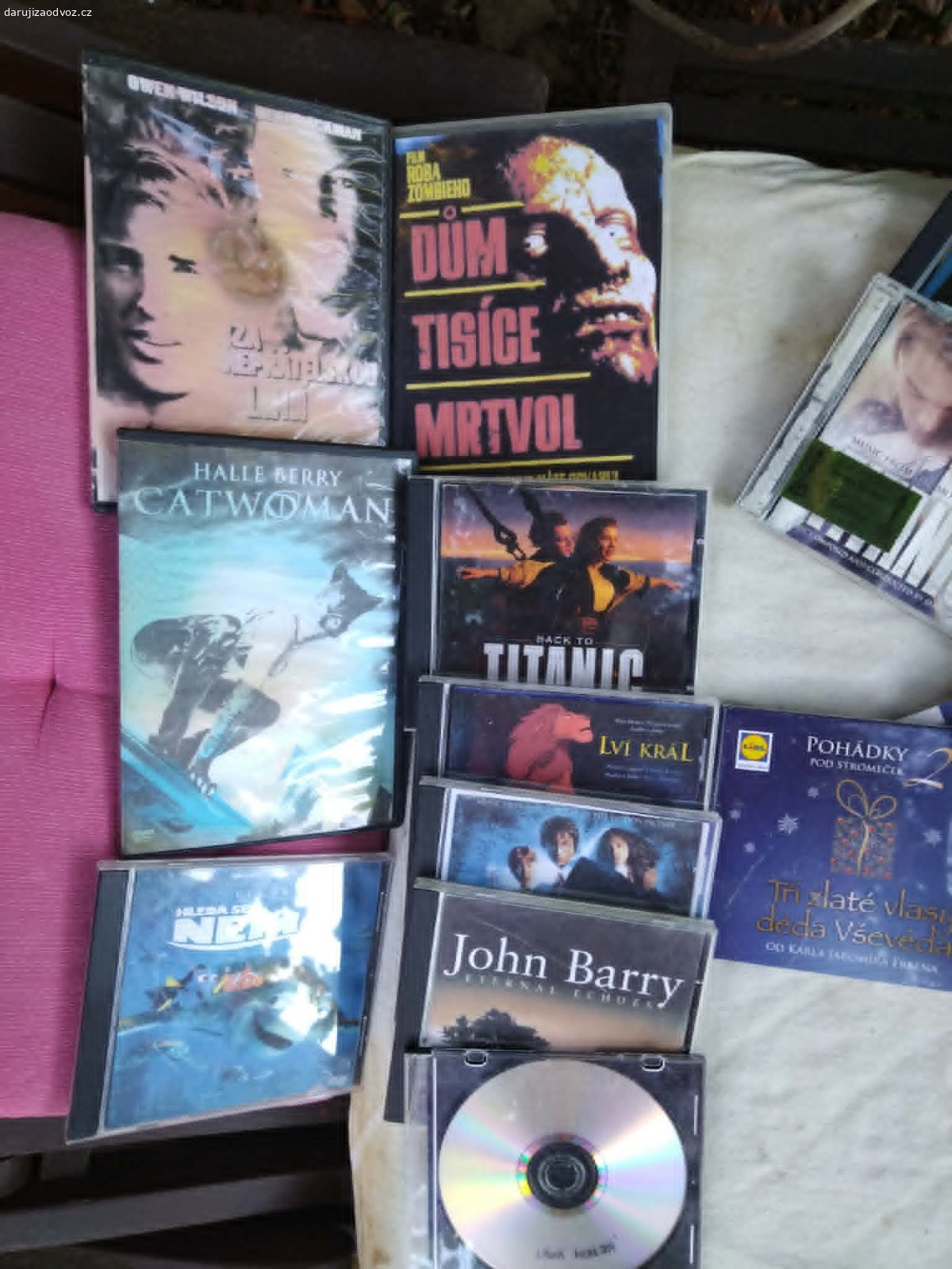 Cca 30 originálních DVD/CD. Daruji (lahev bílého vína potěší - není podmínkou)  sbírku filmů na DVD, hudebních CD a k tomu sadu prázdných krabiček na organizaci. Vše v zachovalém a plně funkčním stavu. Ideální pro sběratele nebo fanoušky klasických nosičů.1. Originální DVD filmy a CD s hudbou (cca 30 kusů):Filmové hity & klasika: Titanic, Catwoman, Hledá se Nemo, Temné patvary, Odysseus, Řek Zorba, Mlčení jehňátek.Česká filmová zábava: Tři tygři proti všem, Ulovit miliardáře. Akce & Horor: Dům tisíce mrtvol, Živí mrtví, Rivalové pod rudým sluncem (Charles Bronson).Pohádky & Hudba: Výběr pohádek na CD, hudba John Barry, několik dalších filmových a hudebních disků (včetně papírových obalů), a přidám nahrané disky (jsou na levé straně) - k odvozu Praha 10-Strašnice