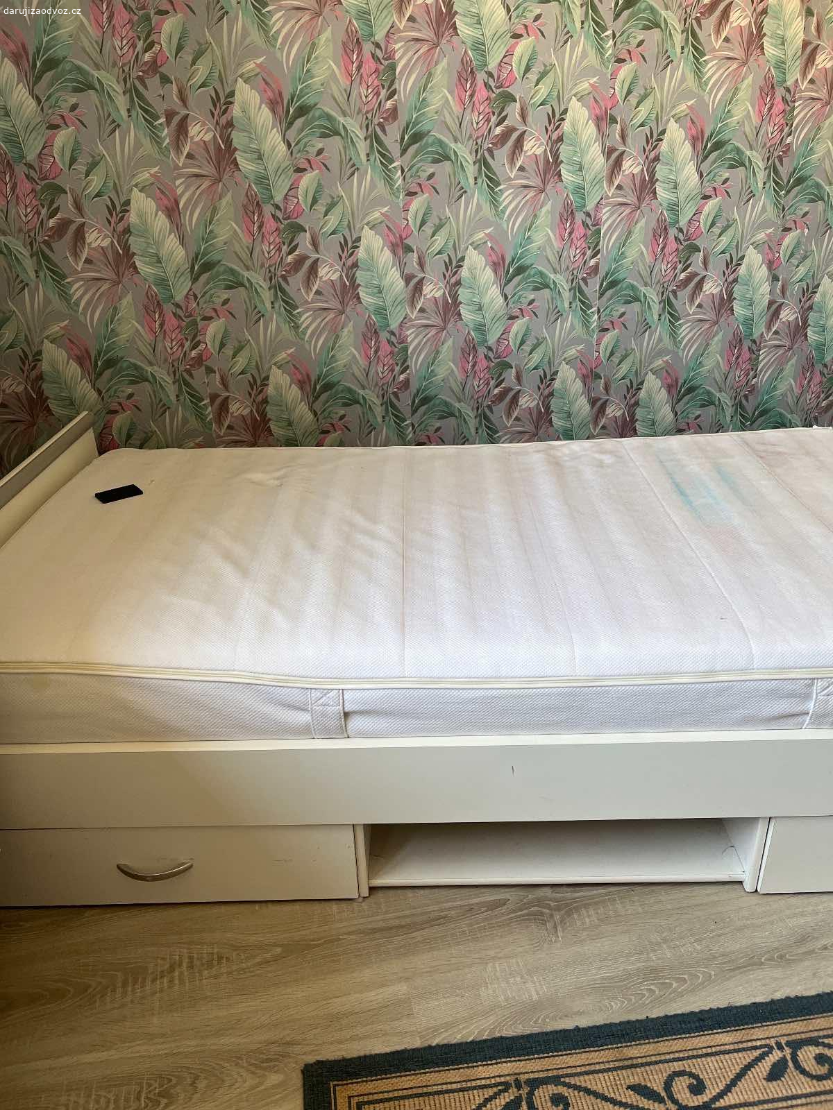 Daruji postel. Daruji postel s matrací, z boku jé prasklá, narychlo opravená, ale plně funkční