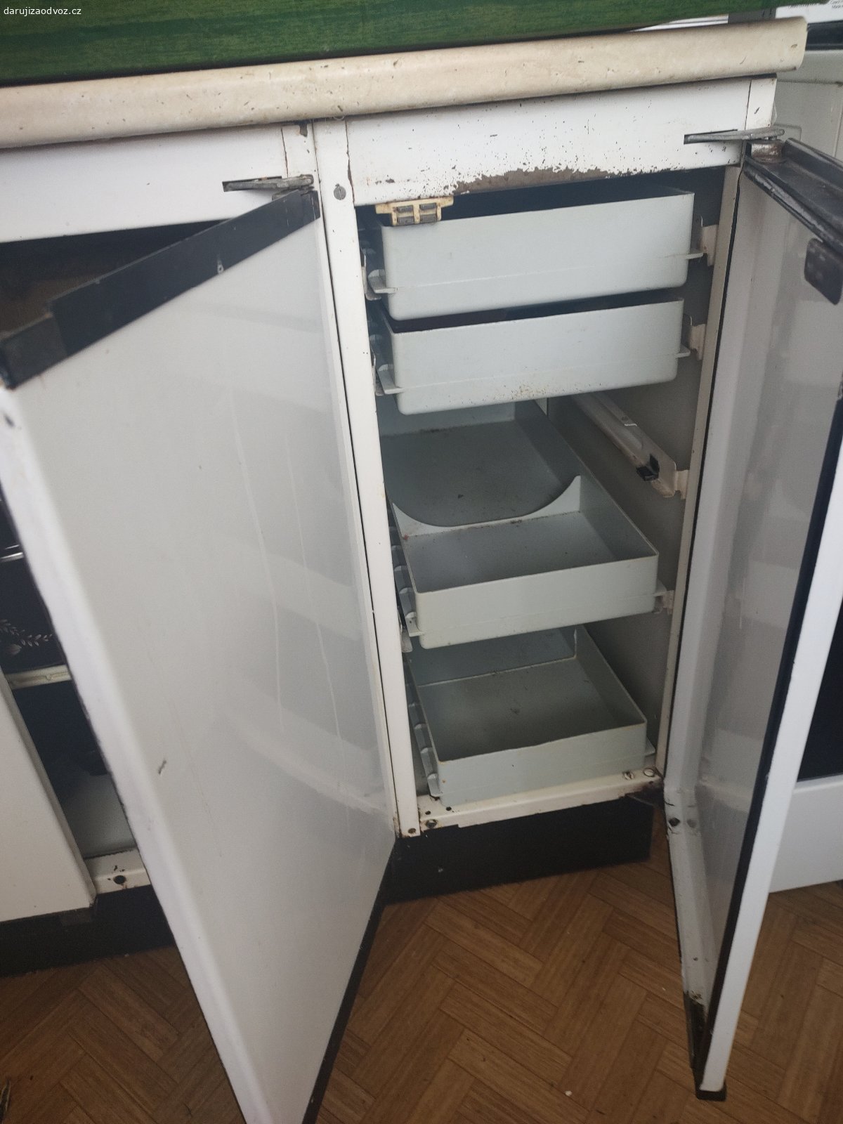 Daruji starou kovovou kuchynskou linku. 5 hornich skrinek, 3 dolni skrinky: vyska od zeme po desku 84cm, sirka prvni dolni skrinka 60 cm, drezova 90 cm sirka a suplikova  na pribory 30 cm sirka, deska delka 180cm, horni skrinky 5 x: ctyri skrinky sirka 60, vyska 65 a jedna nad digestori 60 sirka, 37 vyska, vse k vlastni demontazu a odvozu z 5. patra panelaku Zlin Jizni svahy - je to dost tezky plech, tak treba pro nekoho do dilny nebo vlhka, kam nejde dat drevenou kuchyn