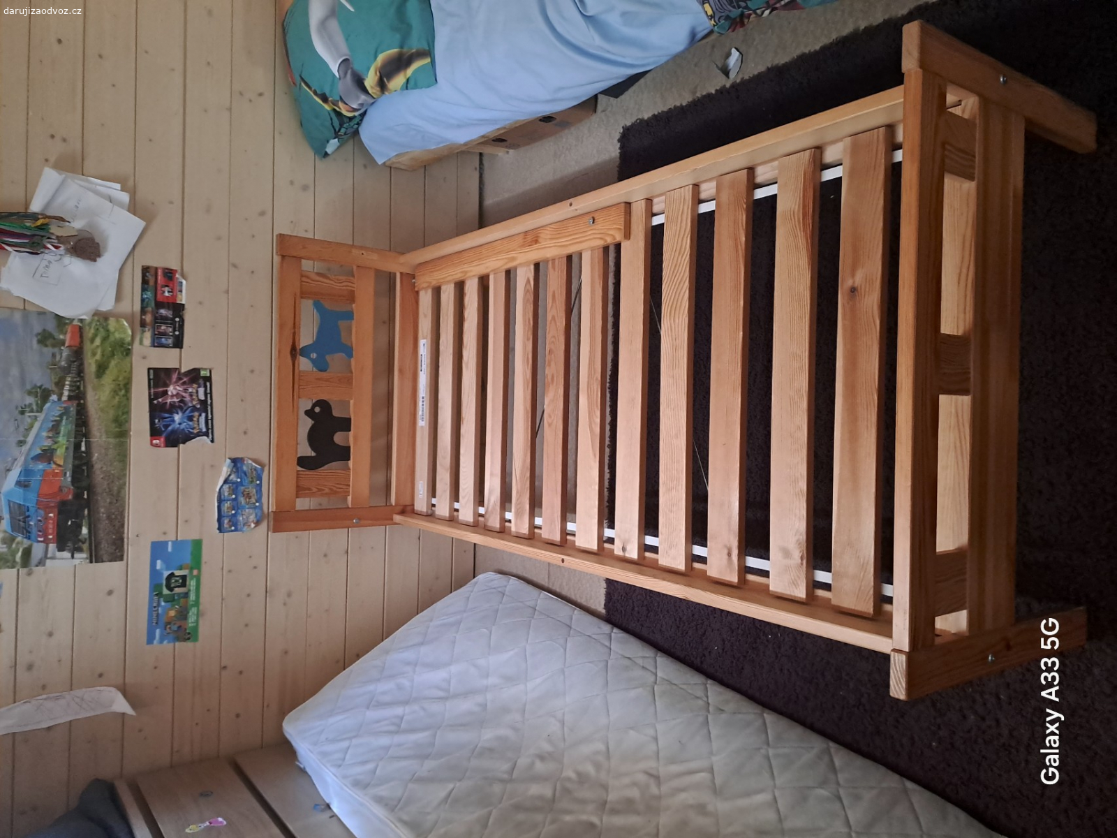 Dětská postel. U boční zábrany chybí šroub. Rýhy v bočnici.