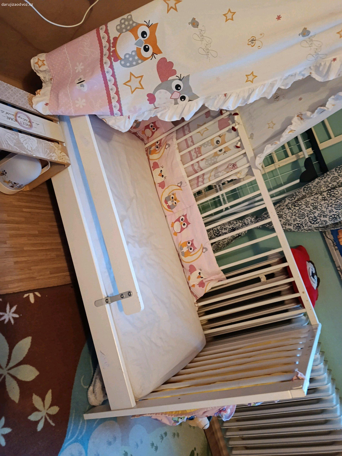 dětská postýlka. daruji dětskou postýlku
postýlka je po 3 dětech. jediné vady jsou oloupani laku (fotka) 
k postýlce jsou 3 peřinky, 6 povlaků na peřinky, polštářky, nebesa, 3 prostěradla. zavinovačka (v sadě s nebesy) mantinel.
jen SMS prosím.
