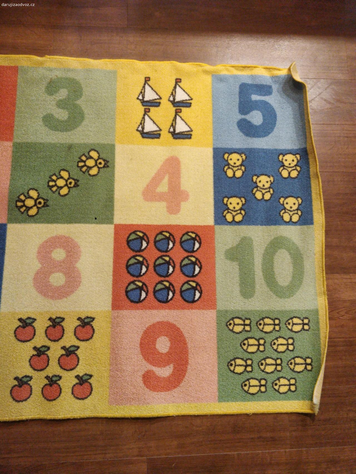 Dětský koberec. Koberec s čísly 1-10 a obrázky s odpovídajícím počtem předmětů. Rozměry 147×100 cm. Lehce znečištěný.