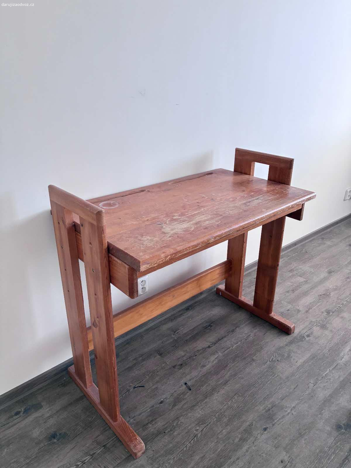 Dřevěný stůl. Daruji dřevěný stůl, možnost polohování výšky. Na desce je vidět opoužívání.