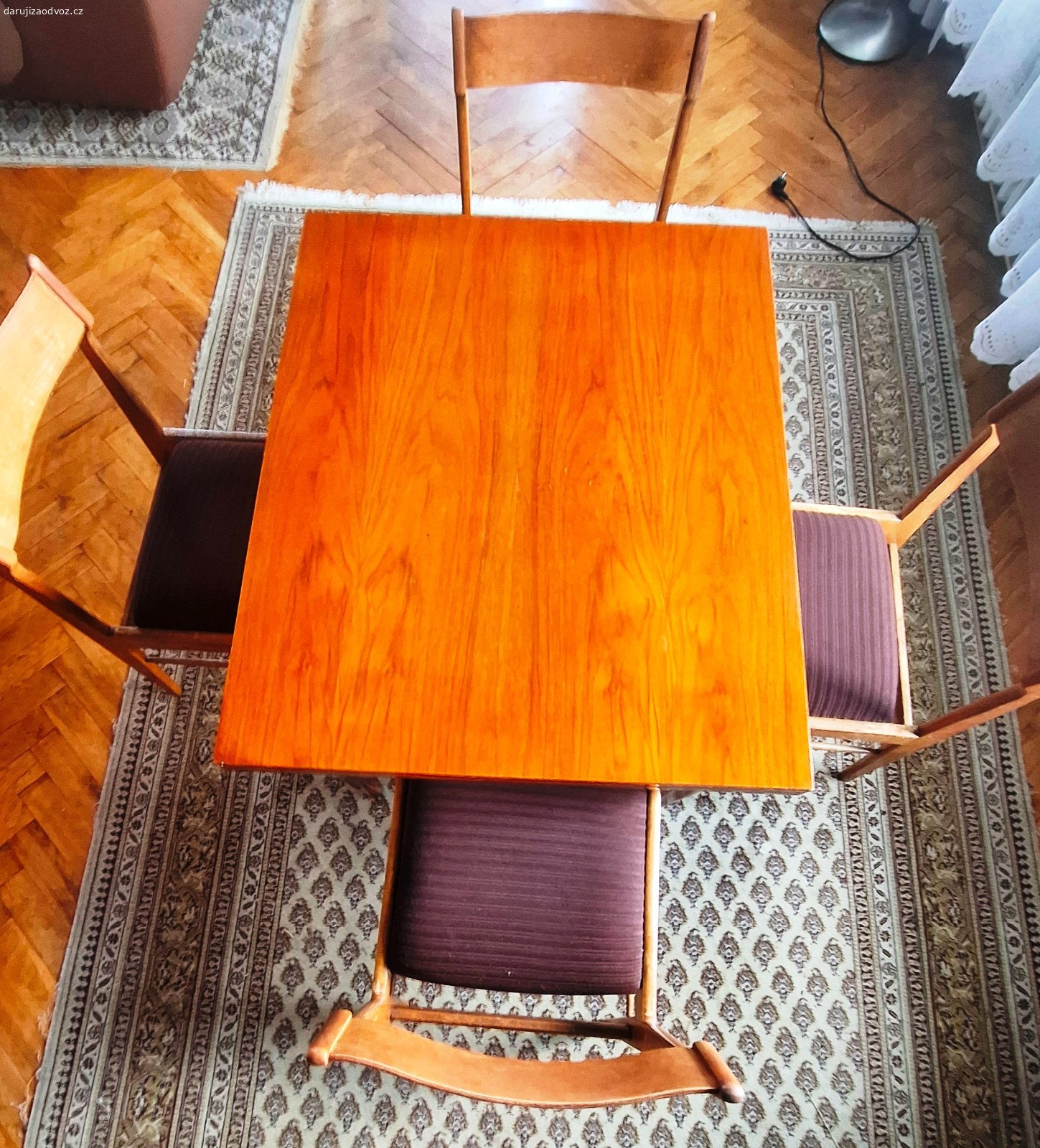 Jídelní rozkládací stůl (ořech) + 4 židle. Originální, velmi zachovalou retro sadu dřevěného nábytku z období československého designu (přelom 50. a 60. let, Brusel). Set se skládá z rozkládacího stolu a 4 designových židlí. Na spodní straně stolu je kompletně dochovaný původní papírový štítek výrobce.

Výrobce: ČESKÝ NÁBYTEK, n. p., provozovna Liberec (Sdružení nábytkářského průmyslu Brno)
Model/Výrobek: 42-341
Materiál a provedení: Kvalitní ořech, lakovaný povrch s krásnou texturou dřeva.

Židle: 4 kusy s elegantně tvarovaným opěradlem. Tmavě hnědé čalounění s jemným svislým proužkem je čisté, neprosezené a ve velmi zachovalém stavu.

Stav: Vše je v původním stavu, dřevo i lak nesou pouze minimální známky šetrného používání. Žádné hluboké škrábance nebo poškození. Rozkládací mechanizmus stolu (kovové panty) je plně funkční a pevný.

Rozměry stolu: (výška x šířka x délka):  75 / 66 / 115 cm (ve složeném stavu)

Nádherný designový set, který okamžitě zapadne do moderního i retro interiéru.

Odběr: Pouze osobní odběr ve Zlíně