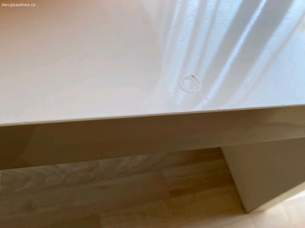 Konferenční stolek. Chtel bych darovat  konferencni stolek (120x42x40 cm)-ma drobne vady (viz foto). Material je laminovana deska -drevotriska v bile leskle barve.
Vzhledem ke sve vysce ho lze vyuzit i jako detsky stolek. Ma prihradku na casopisy/knihy.
Pouze osobni predani v Hostivici nebo Praha 13.