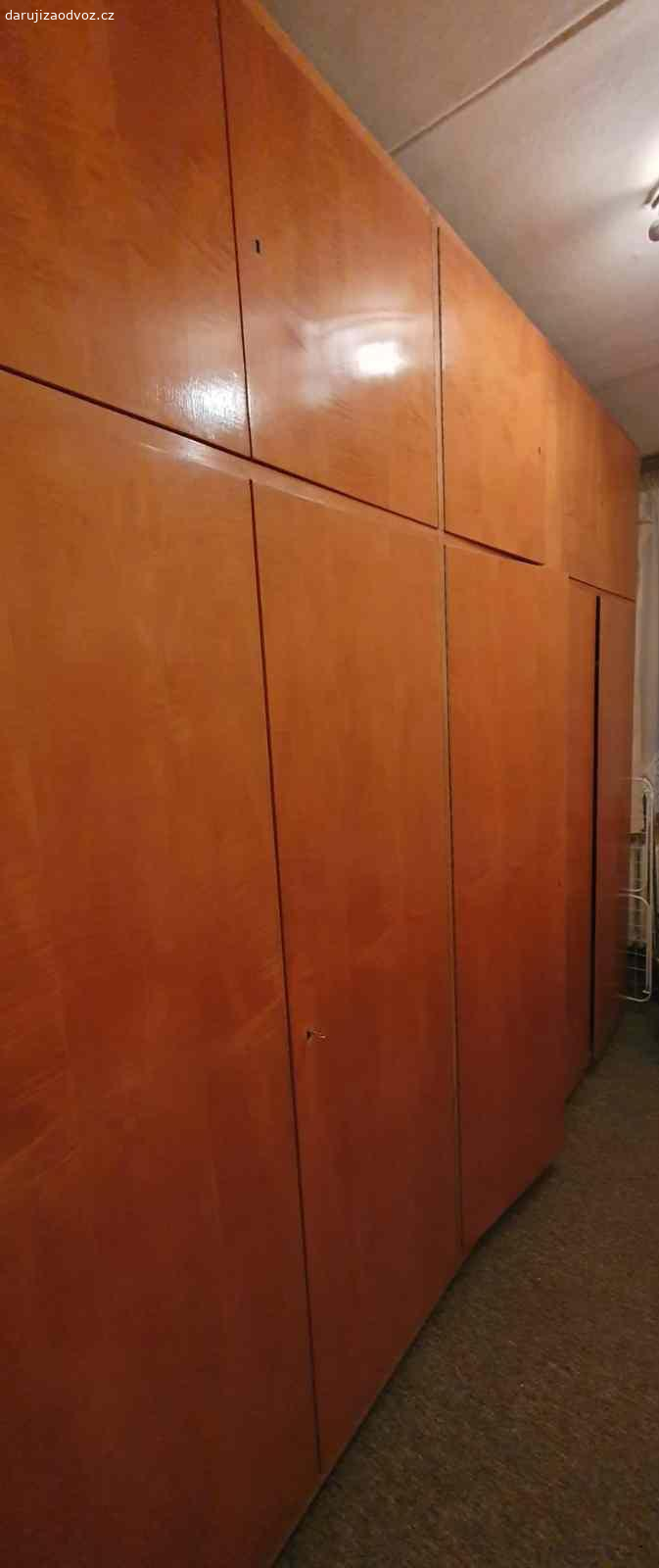 Lakovaná bytelná šatní skříň (stěna). Šatní skříň v rozměru cca d 3,5m x v 2,5m, sešroubované v celek,  dva díly na ramínka, každé straně část s policemi
Nutná demontáž a vlastní odkaz 
V bytovém domě je velký výtah