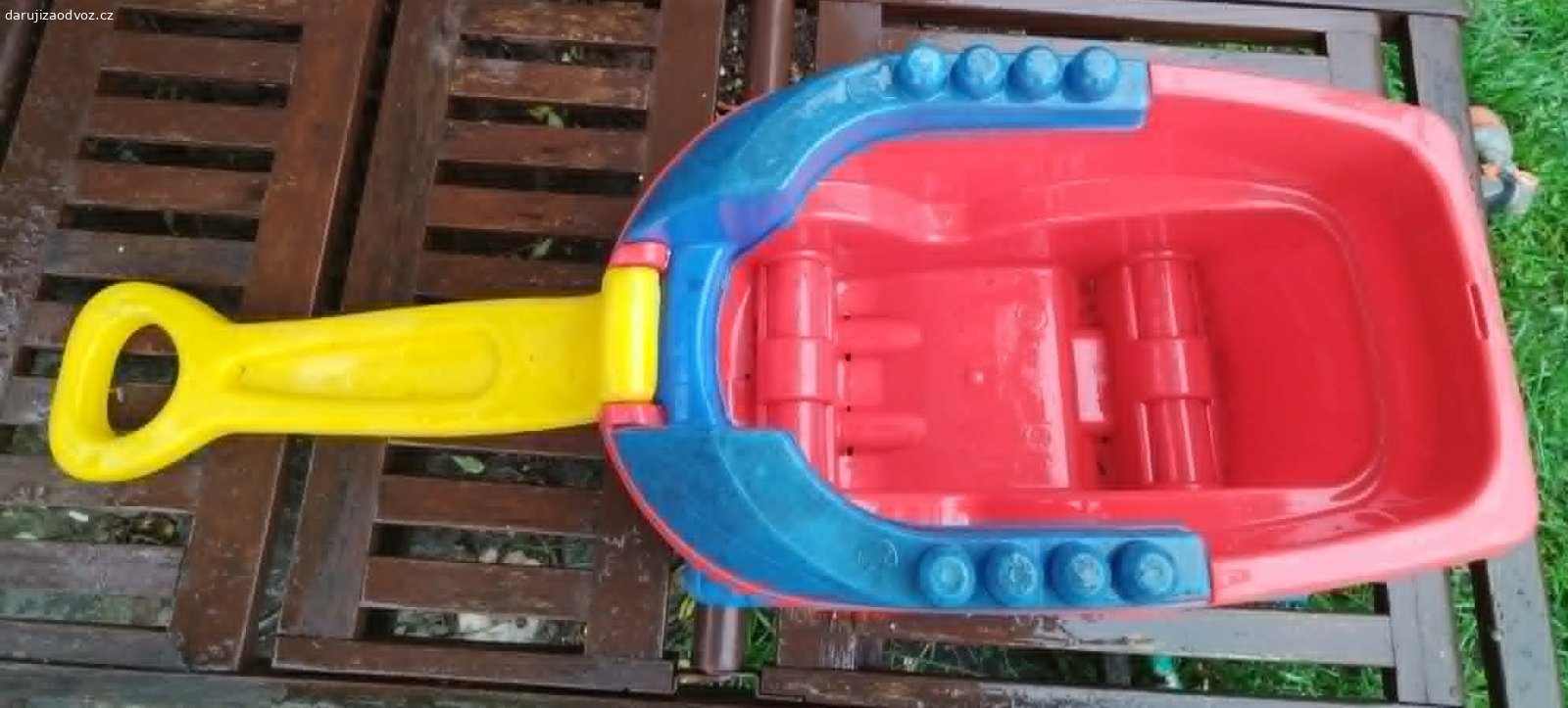Plastový tahací vozík Mega Bloks – bez kostek. Daruji (ovoce pro děti potěší, není podmínkou) dětský tahací vozík značky Mega Bloks (Mattel). Vozík je používaný, nese známky hraní viditelné na fotkách, ale je plně funkční, robustní, plast nikde nepraskl, poslední dobou byl na zahradě. Má sklápěcí žluté madlo a modré bočnice s výstupky, na které lze kostky přímo stavět. Ideální jako úložný box na hračky nebo na převážení venku. Předám Praha 10-Strašnice, samostatně BEZ stavebních kostek.