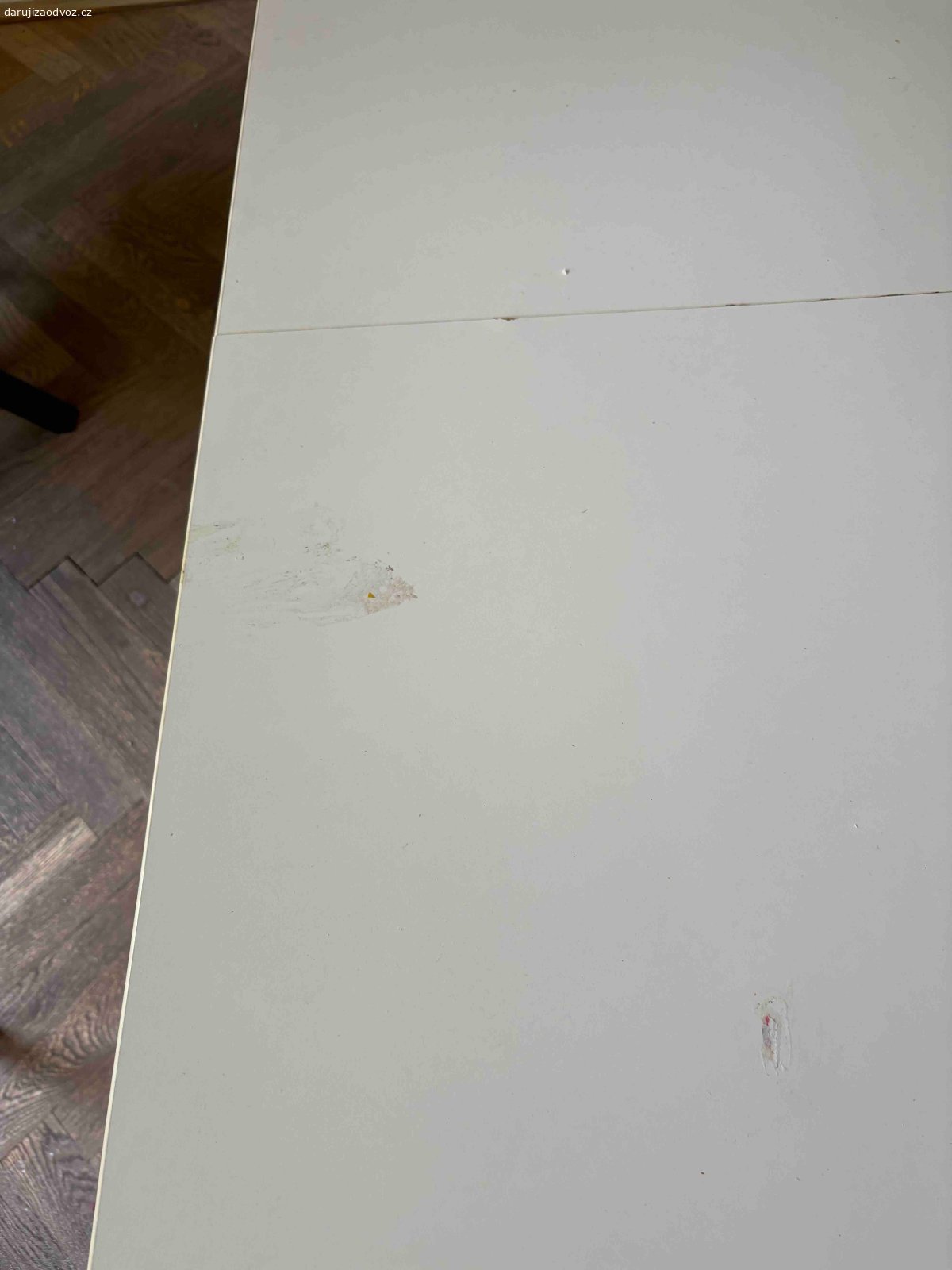 Pracovní stůl. Daruji bílý pracovní stůl s černými nohami. Rozměry 140x140cm. Lehce poškozená deska.