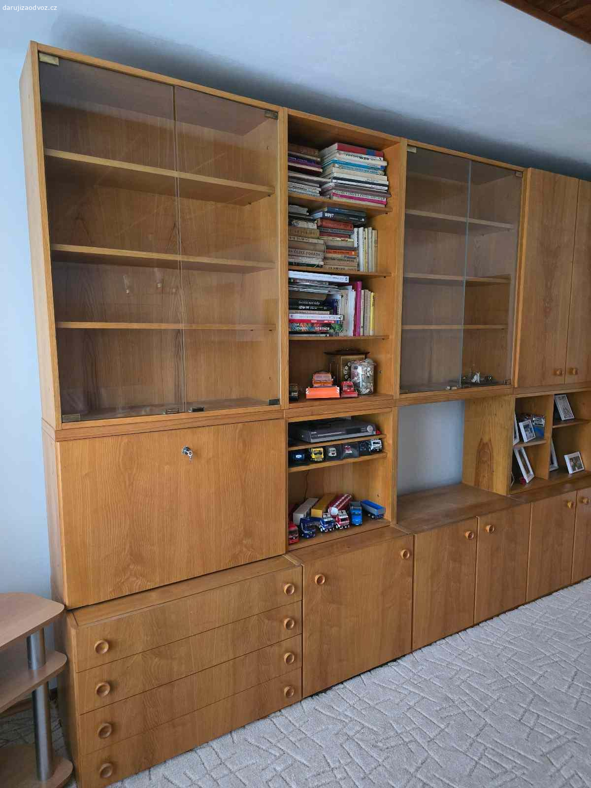 retro obývací stěna. Nabízím retro obývací stěnu. Vlastní doprava, vynesení. Velice dobrý stav, komplet vše co je na foto. Přibližné rozměry jak je vidět na fotkách široká 4m, na výšku cca 230cm a hloubka je od 30 do 40cm. Jednotlivé sekce mají lehce přes 80cm na šířku a na výšku kolem 110cm. Nejlépe jako celek. Může ještě velice dobře posloužit, na svůj věk je zachovalá a bylo by škoda jí vyhodit.