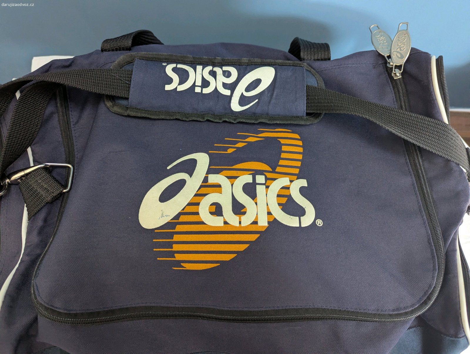 Sportovní taška Asics. Daruji sportovní tašku značky Asics. Všechny zipy a popruhy jsou plně funkční. Velká kapsa je bez defektu, malá kapsa je na dně v jedné části děravá. Pouze osobní předání v Jablonci nad Nisou a blízkém okolí.