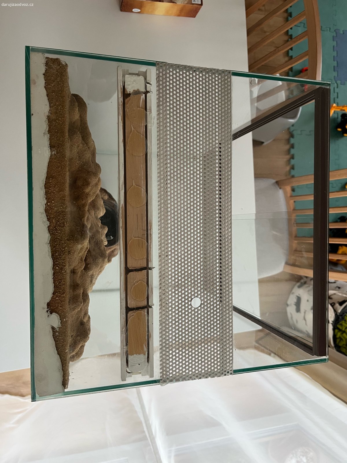 Terarium 40 x 40 x 60cm. Daruji za odvoz terarium orientované na výšku o rozměrech 40 x 40 x 60cm. Funkční, jen by chtělo opravit okrasné pozadí, které má již pár dírek, kam se schovává krmný hmyz. V horní části díra o průměru 1,3cm pro nainstalování žárovky.